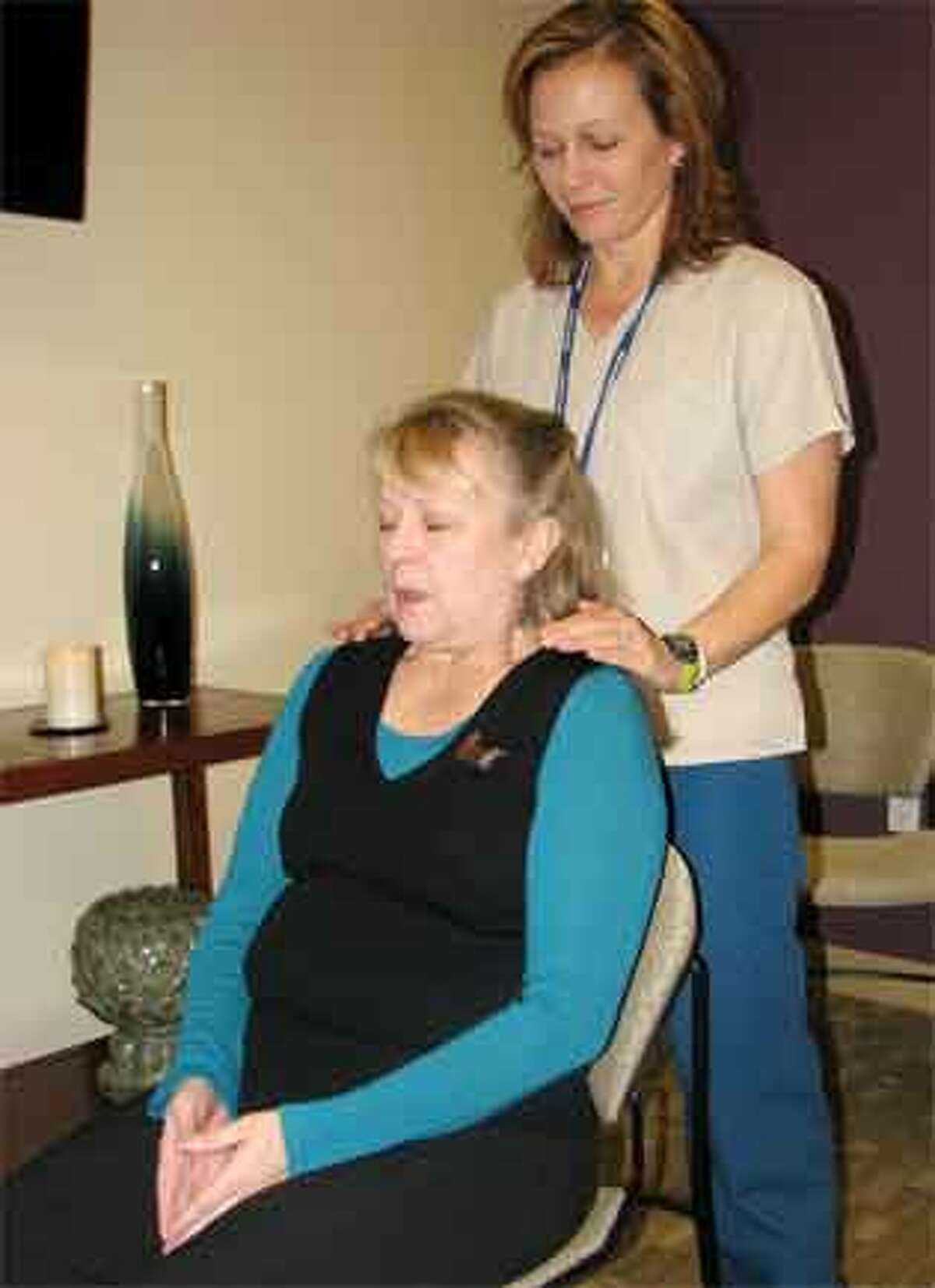 Griffin Hospital radiation therapist Laura Howell performs a Reiki treatment on Kim O'Neill, a massage therapist at Griffin.