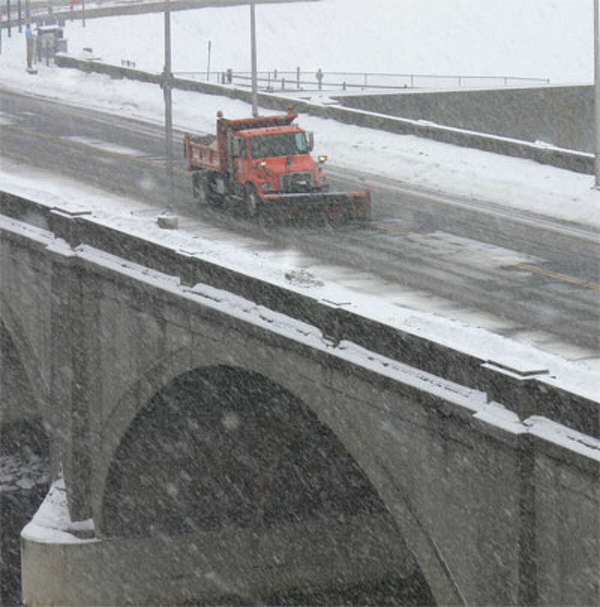 A plow clears snow on the Derby-Shelton Bridge over the Housatonic River.