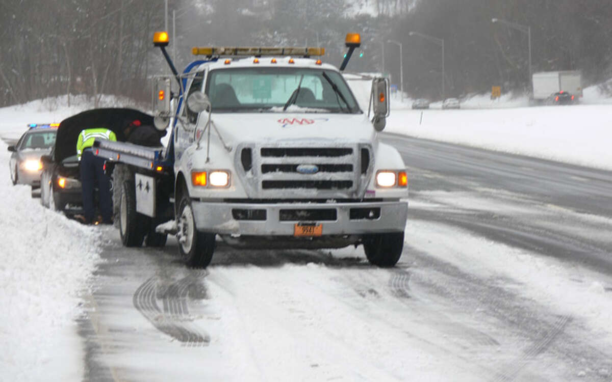 A tow truck driver and state trooper assist a motorist on the side of Route 8 southbound, near Exit 13 in Shelton, at about 2:30 p.m. Thursday.