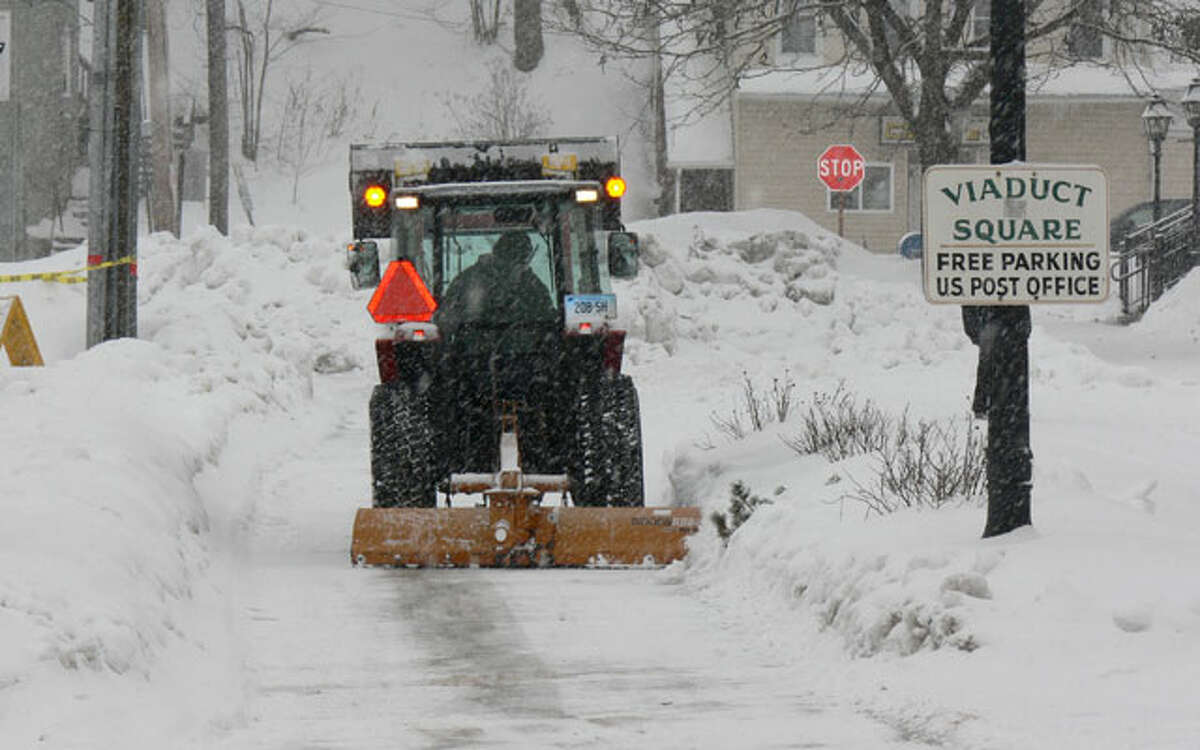 Following a past storm, snow is removed from near the municipal parking lot in front of the post office in downtown Shelton.