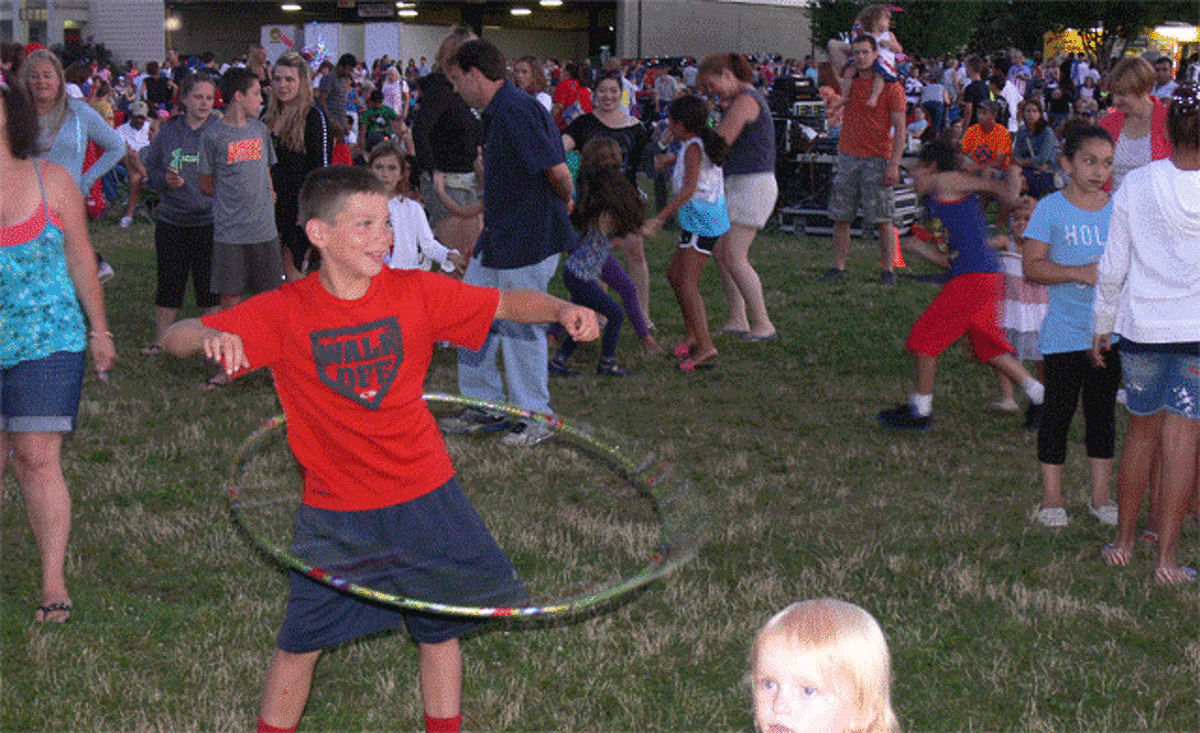 A youngster does his thing with a hula hoop while listening to the music, prior to the start of the fireworks.