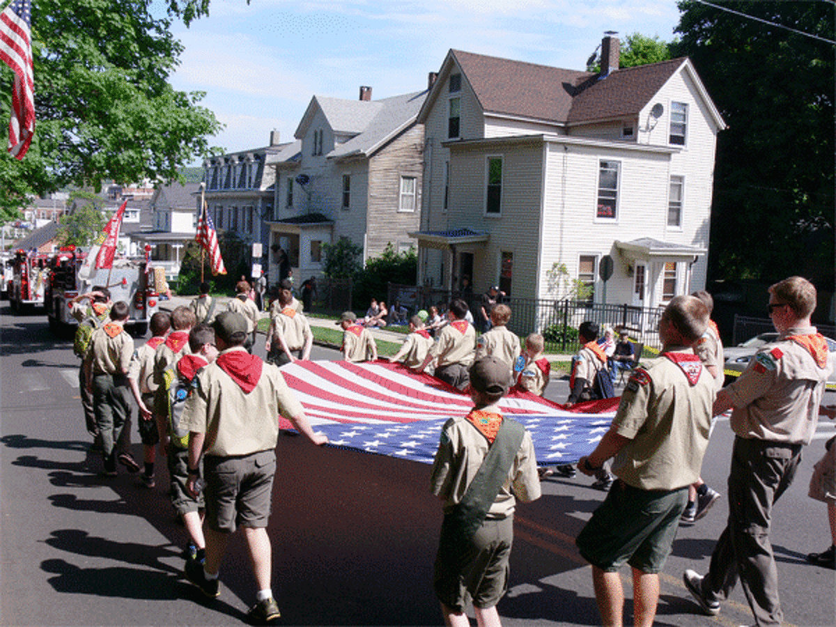 Members of a Boy Scout troop from Shelton’s Huntington section carry a large American flag in the parade.