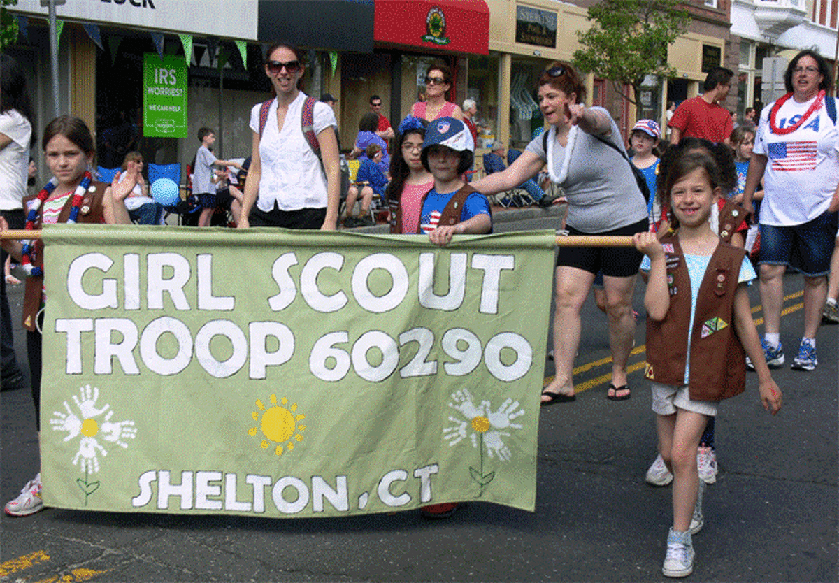 Members of Girl Scout Troop 60290 in Shelton march on Howe Avenue.