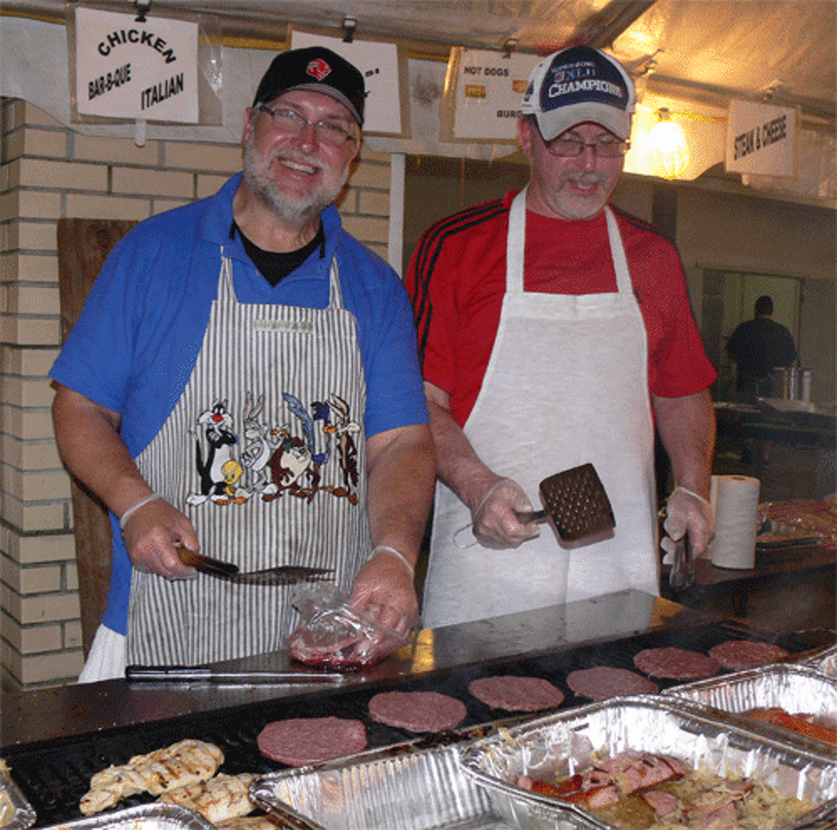 St. Joseph Parish members Bob Peel, left, and Tony Yarrish help with the cooking at the carnival and food fest on Coram Avenue, which continues through Saturday night.
