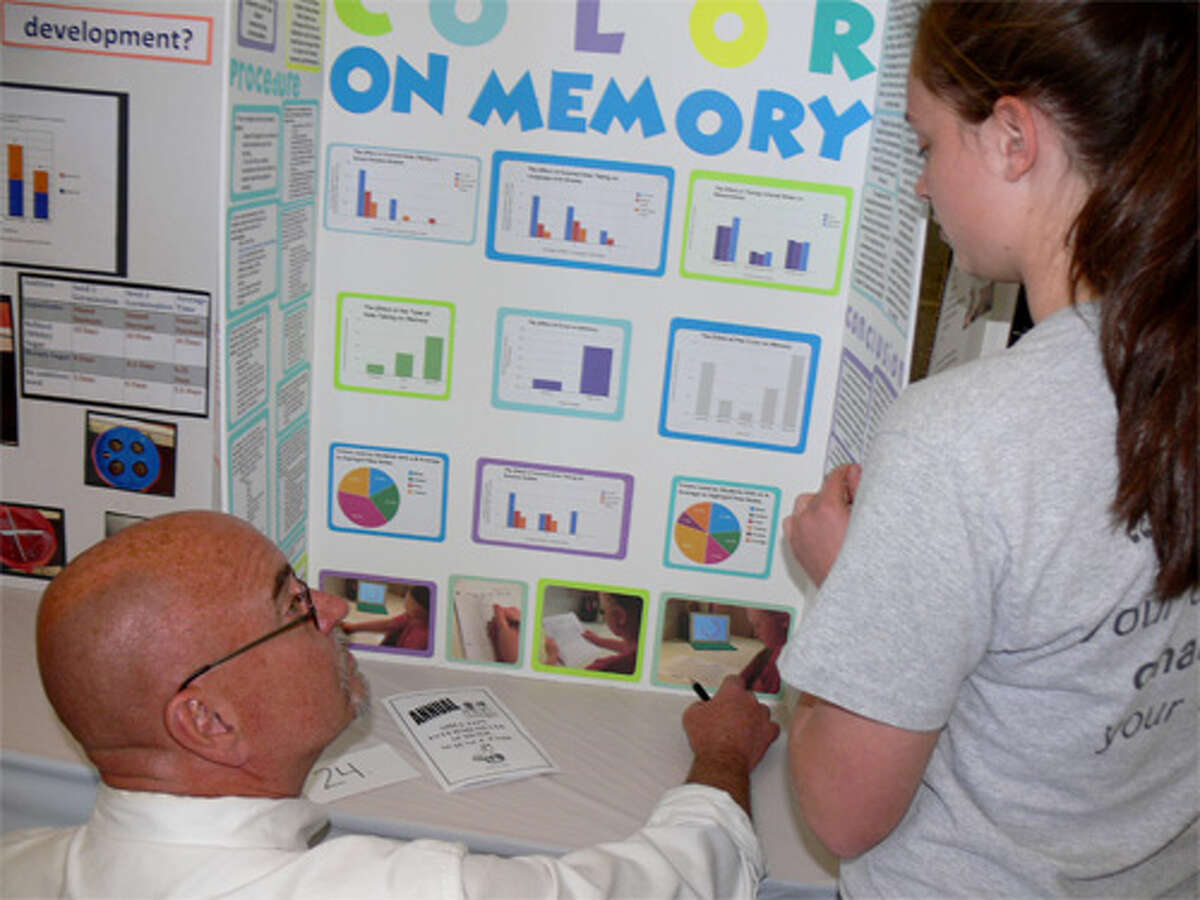 Bob VanEgghen of PerkinElmer talks to student Allison Nielson about her project at the Shelton Intermediate School Science Fair. VanEgghen was a judge in the fair.