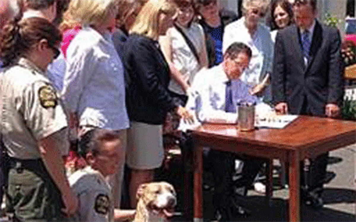 Gov. Dannel P. Malloy, joined by state lawmakers and advocates, signs a bill enacting stricter rules on pet stores and breeders.