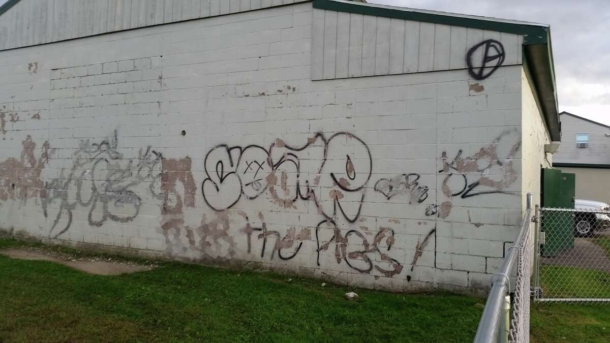 The outer walls of the only bathroom in the Nike recreation site are covered in graffiti with explicit messages and chipped paint. This image has been edited for web to remove explicit language. - Resident submitted photo