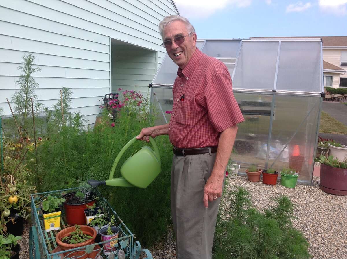 Douglas Osgood watering the garden he had put into The Wesley Village Campus