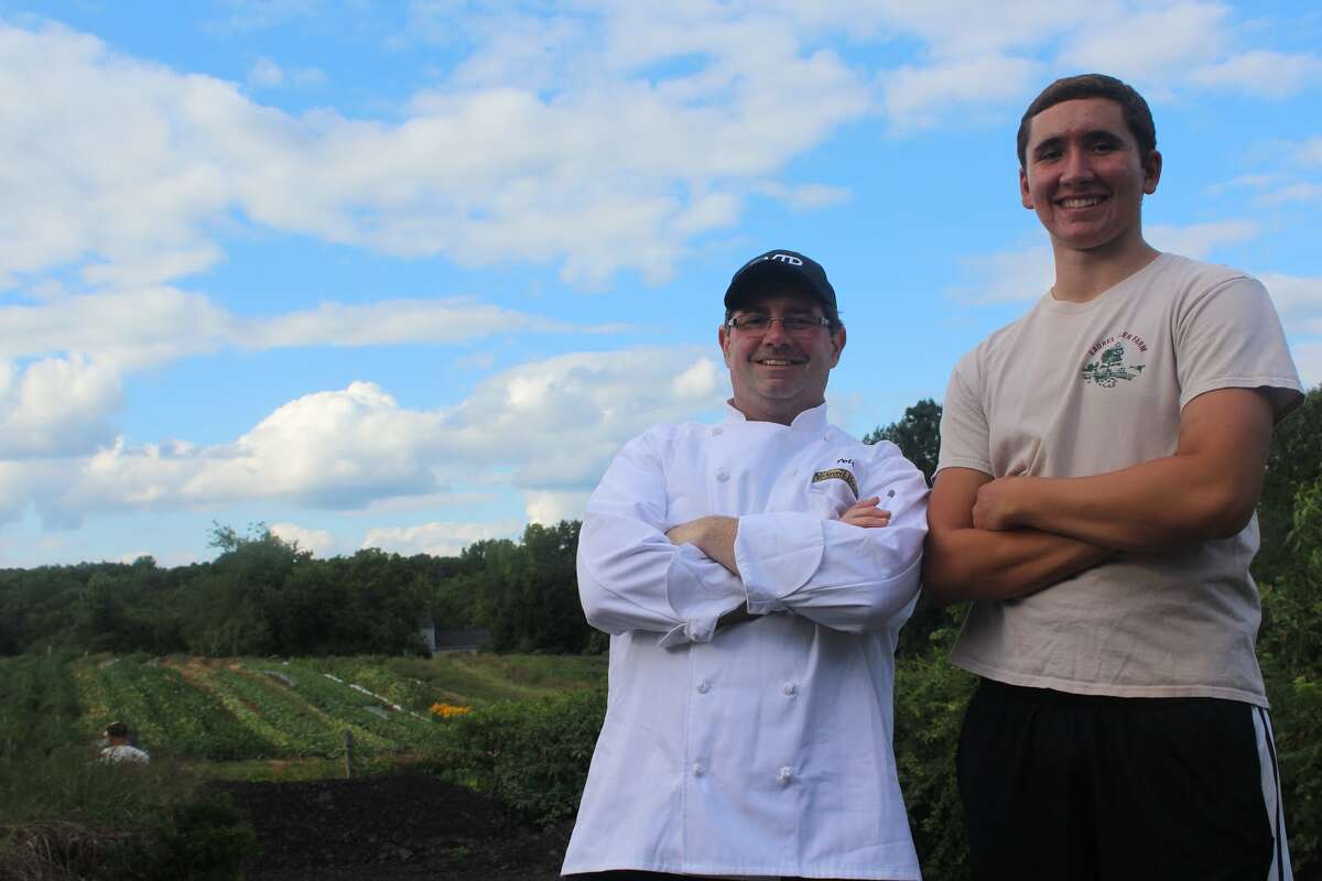 Peter Hamme and Alex Recker in front of the main field of crops at Laurel Glen Farm. (Aaron Berkowitz photo)
