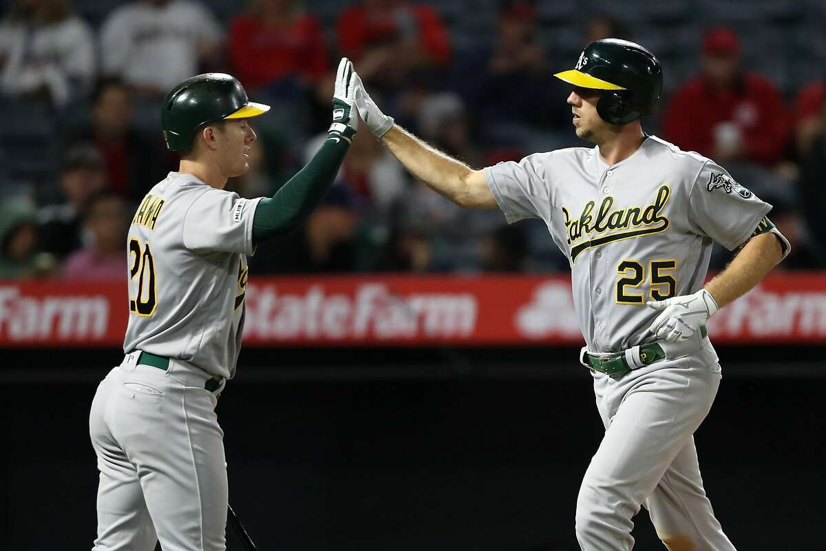ANAHEIM, CALIFORNIA - JUNE 06: Mark Canha #20 congratulates Stephen Piscotty #25 of the Oakland Athletics after his solo homerun during the seventh inning of a game against the Los Angeles Angels of Anaheimat Angel Stadium of Anaheim on June 06, 2019 in Anaheim, California. (Photo by Sean M. Haffey/Getty Images)