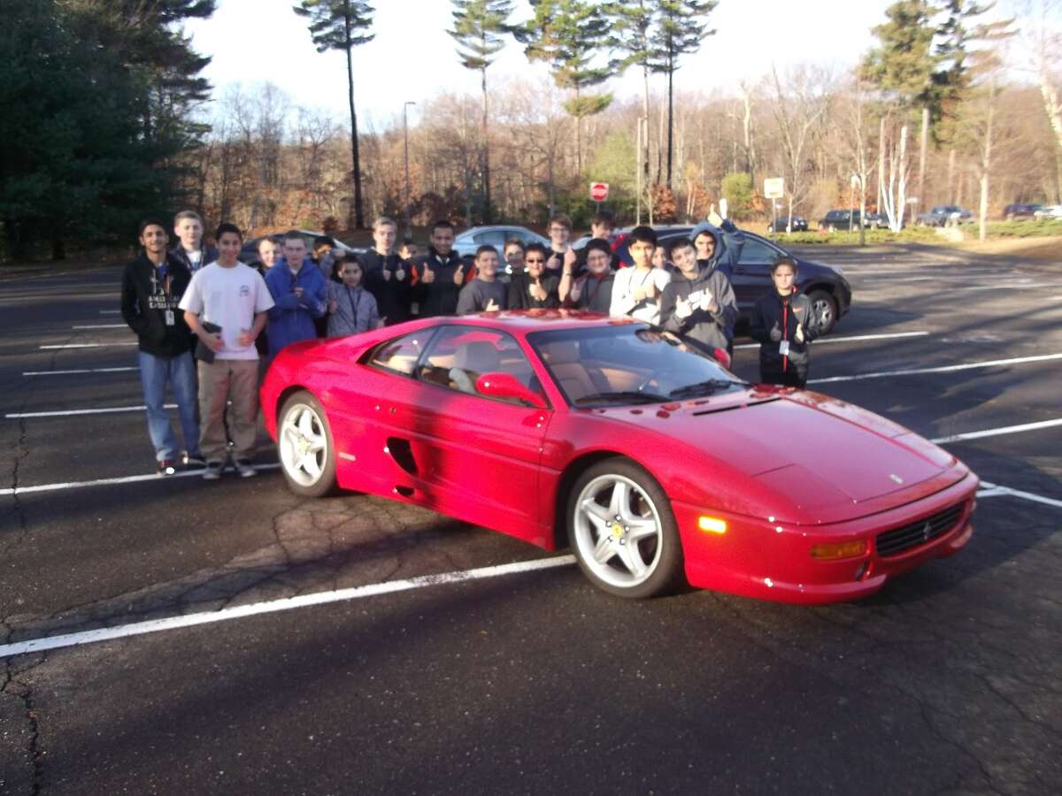 Club members gathered for their traditional pose as they do with each car they look at.