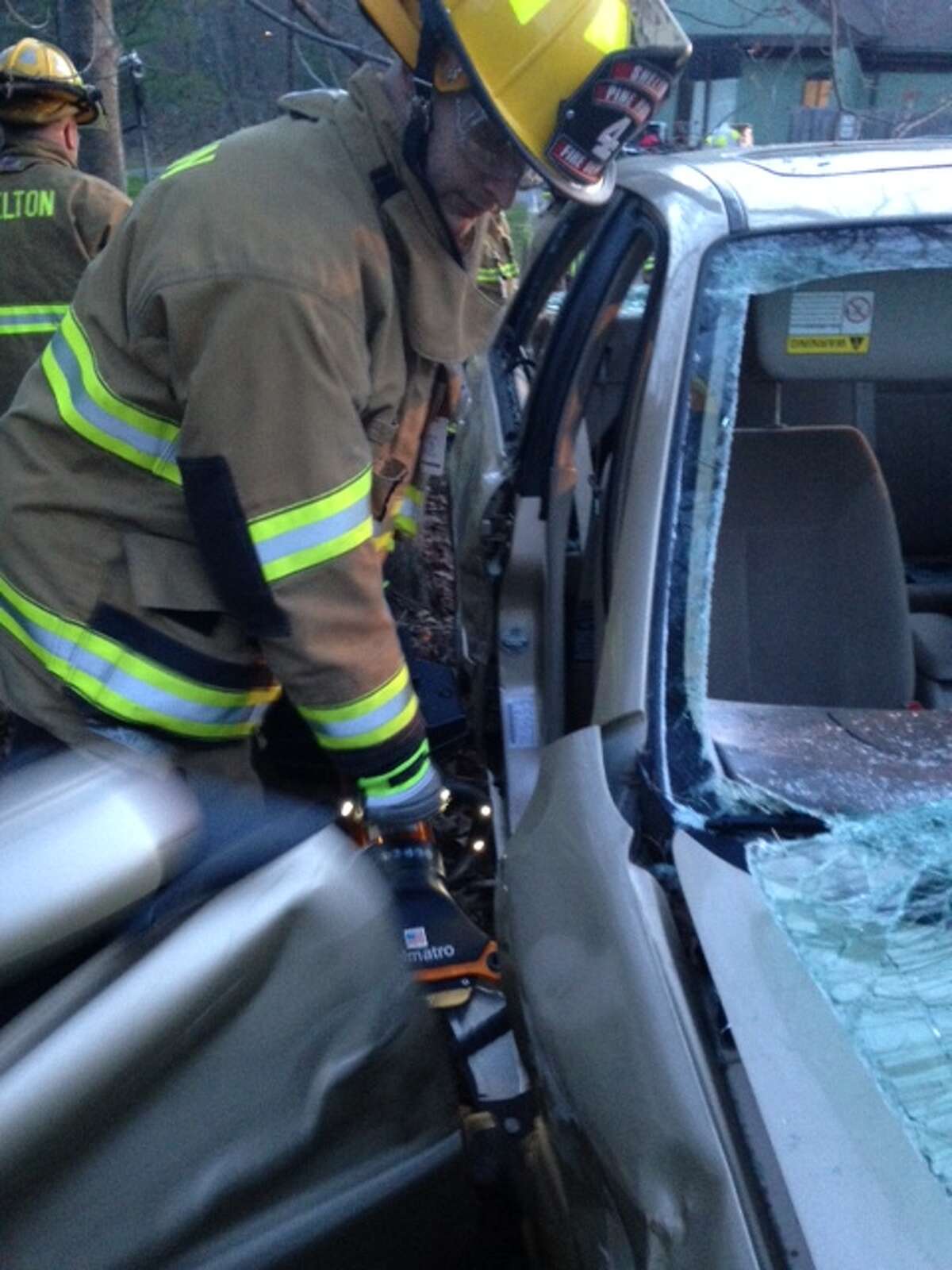 Shelton FF Cody Studwell using hydraulic spreaders to remove a car door.