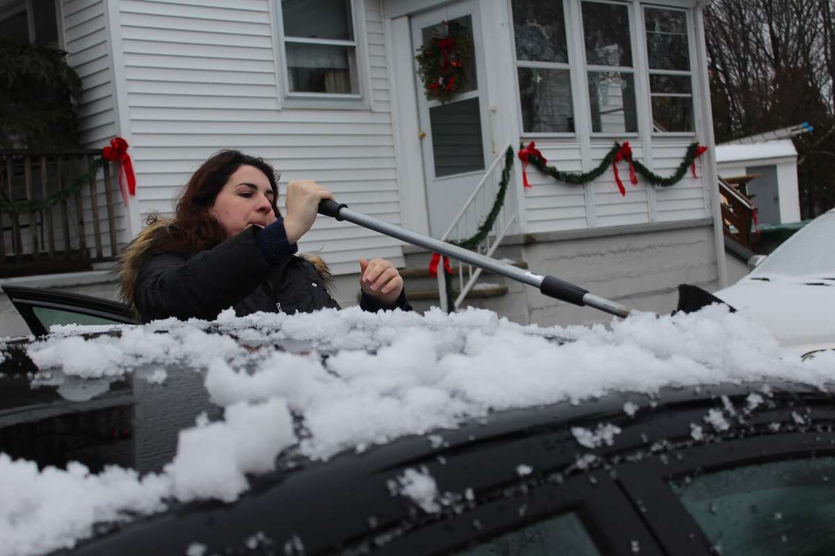 Cara Petitti cleans the first snow fall of winter 2015 off her car before heading to work - Aaron Berkowitz photo