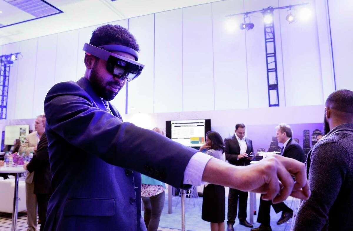 Amid moody and colorful lighting, conference attendant Almutassim Ghazali with Saudi Aramco, tries on an ABB augmented reality headset in the Microsoft room displaying various energy technologies during the second day of CERAWeek by IHS Markit at the George R. Brown Convention Center in 2019. This year’s event has gone virtual, another blow to the region’s convention business.