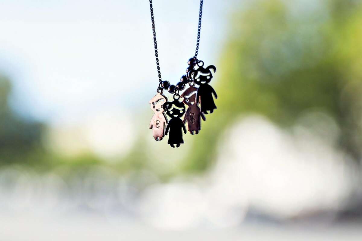 Annette Rivero's (not pictured) necklace with figures of her children hang from her rear view mirror as she drives Lyft in San Jose, California, on Tuesday, June 4, 2019. She was given the necklace for Mother's Day.