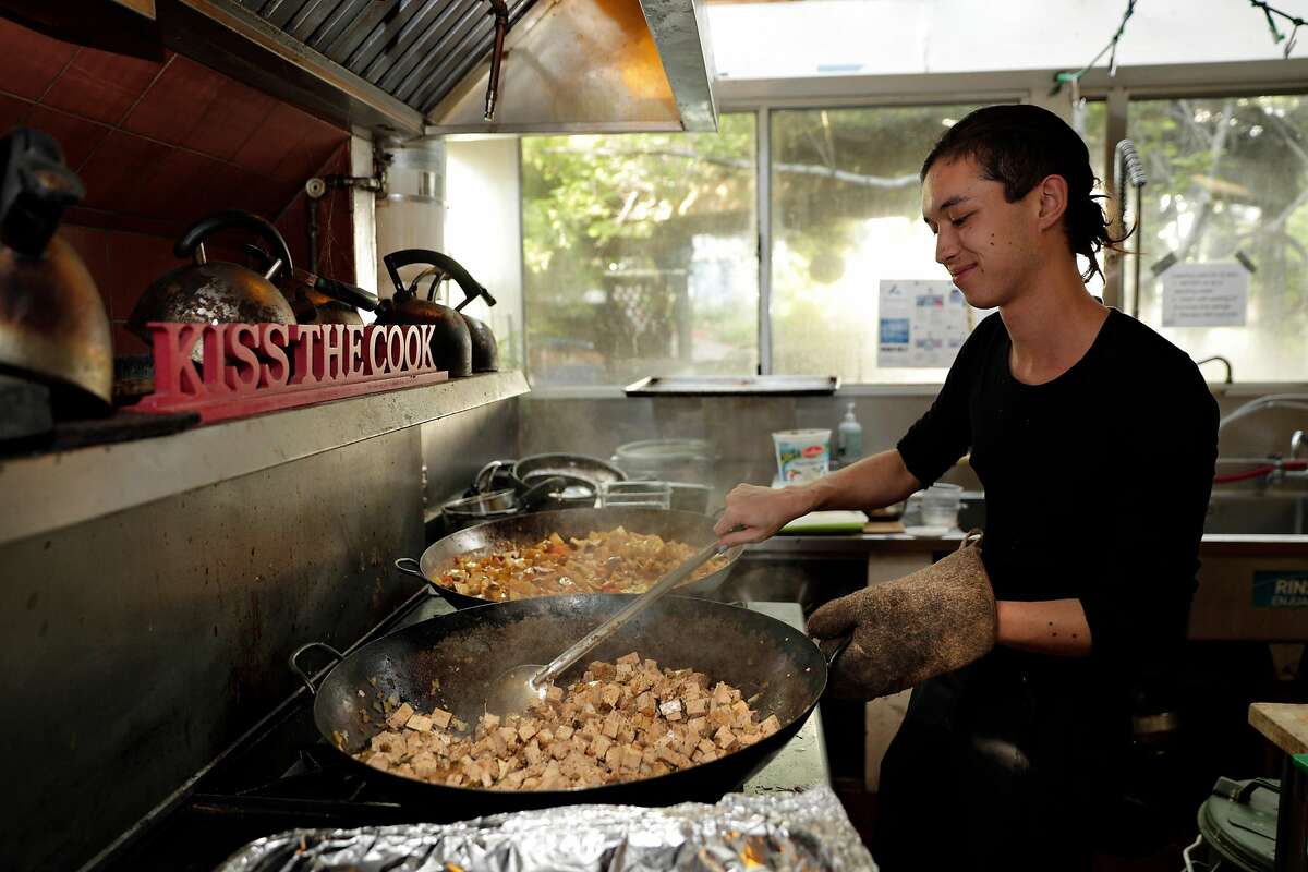 Dylan Burgoon makes dinner for his housemates at the cooperative house known by members as Lothlorien, in Berkeley, Calif., on Tuesday, May 7, 2019. Berkeley's unique co-ops, formed decades ago to give low-income university students a place to live, are turning more affluent and less diverse.