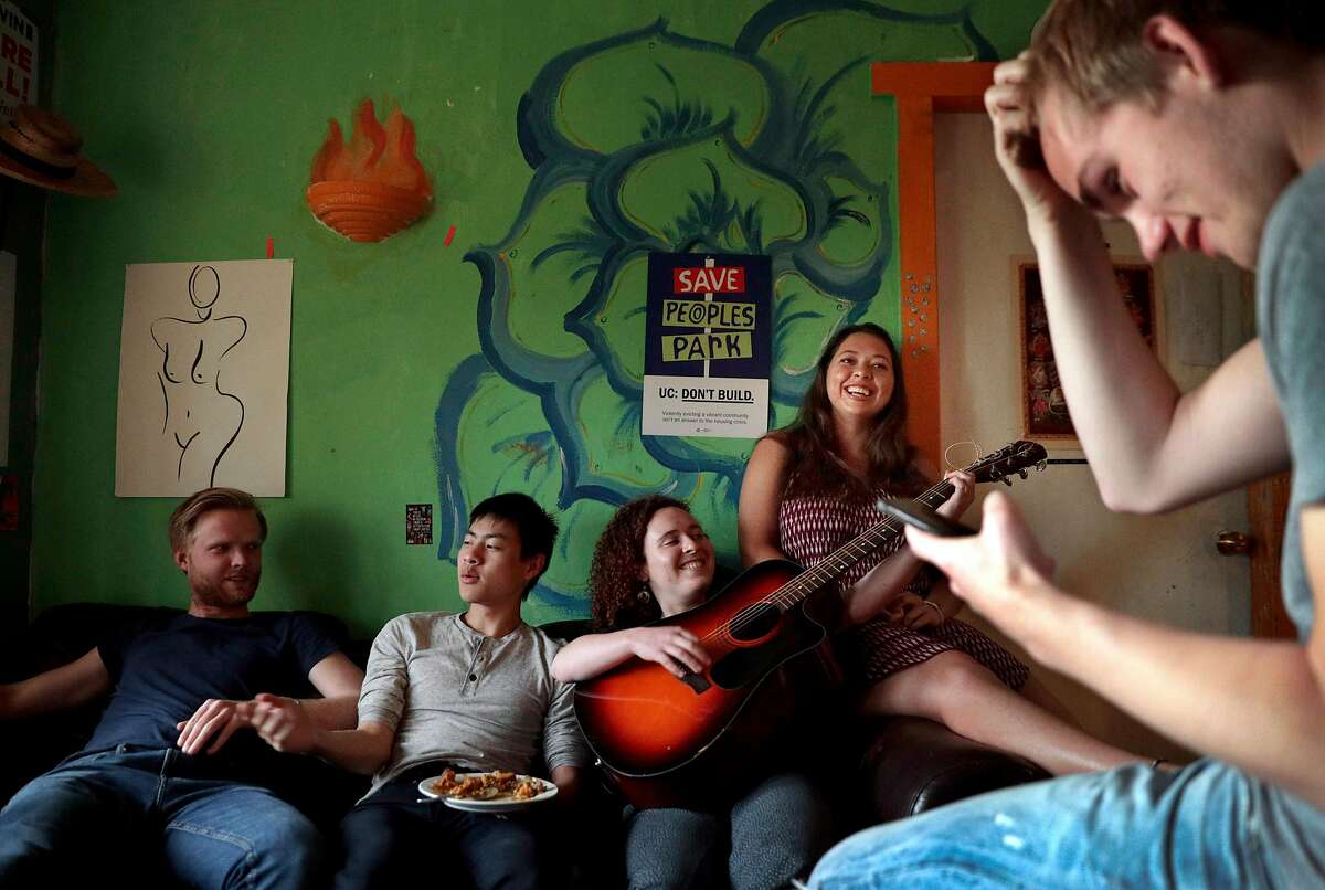 Housemates (l-r) Jonathan Mortenlind, Alex Ye, Daryanna Lancet, Ella Smith, and Niklas Peters spend time in the living room after dinner at the cooperative house known by members as Lothlorien, in Berkeley, Calif., on Tuesday, May 7, 2019. Berkeley's unique co-ops, formed decades ago to give low-income university students a place to live, are turning more affluent and less diverse.