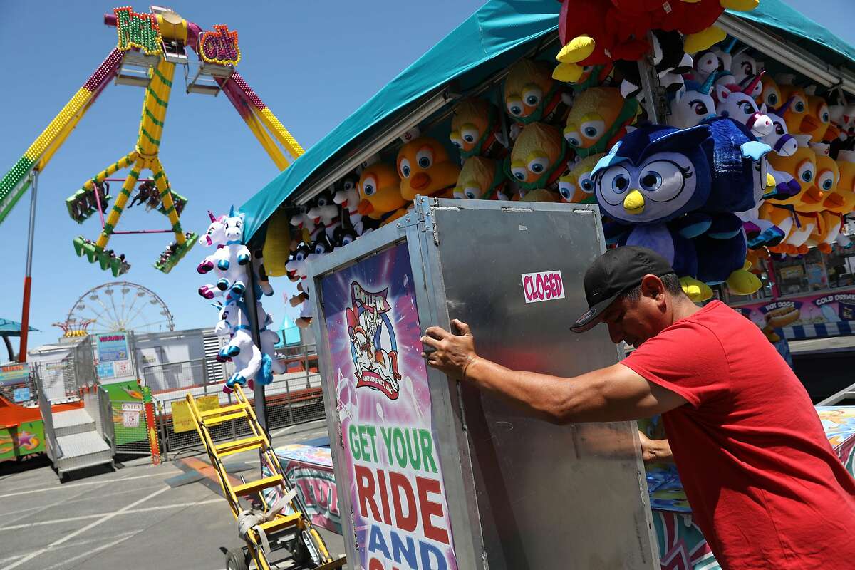 Gabriel Moreno, IT Butler Amusements, moves a ticket machine into position in the carnival section during a media preview of the San Mateo County Fair at the San Mateo Events Center on Friday, June 7, 2019 in San Mateo, Calif.