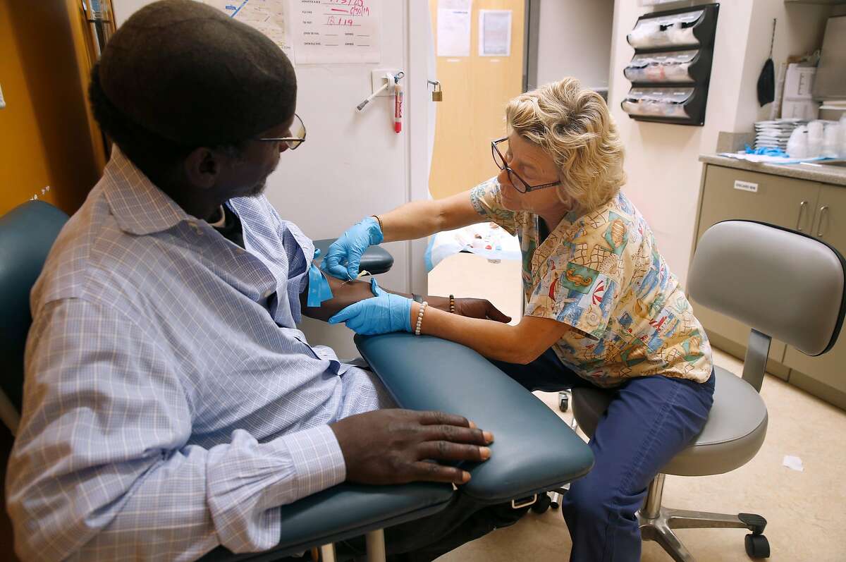 Registered nurse Leslie Stavig draws blood from Robert Reed at the Alameda County Health Care for the Homeless clinic in Oakland, Calif. on Thursday, June 6, 2019. A dozen mayors have sent a letter to the Board of Supervisors urging the release of more funds to handle the county's growing homeless population.