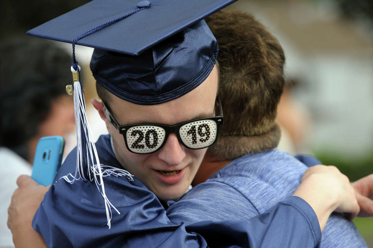 Dominick Boylan gets a hug from a classmate during graduation for the Ansonia High School of Class of 2019, in Ansonia, Conn. June 7, 2019.