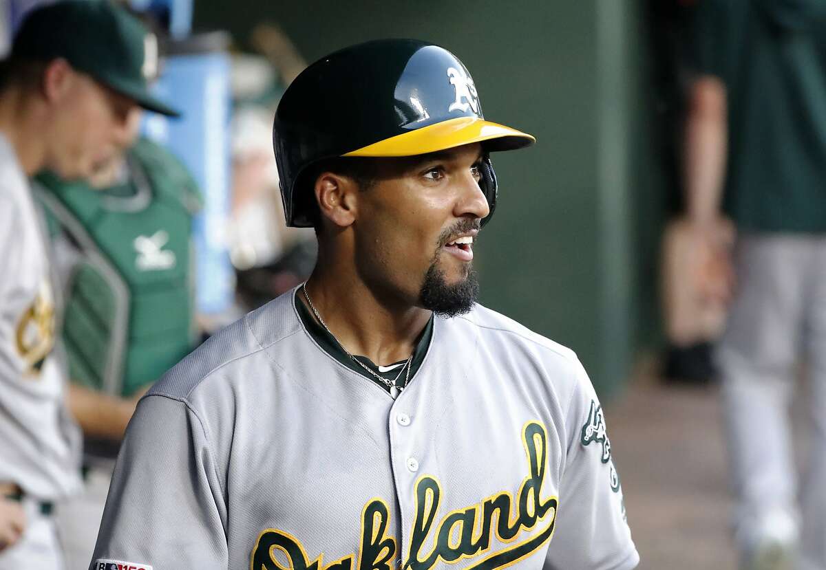 Oakland Athletics' Marcus Semien smiles as he stand in the dugout after hitting a solo home run during the fifth inning of the team's baseball game against the Texas Rangers in Arlington, Texas, Friday, June 7, 2019. (AP Photo/Tony Gutierrez)