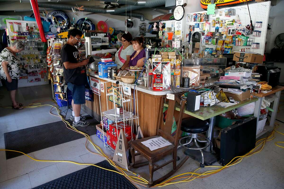 A customer purchases picnic supplies at the Spanish Flat Country Store and Deli where extension cords from a gas generator provides limited power in Lake Berryessa, Calif. on Saturday, June 8, 2019.