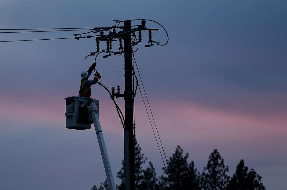 Image: A PG&E worker repairs a power line in fire-ravaged Paradise (Butte County) Story: PG&E restoring power after intentional shut-offs affect 20,500 customers