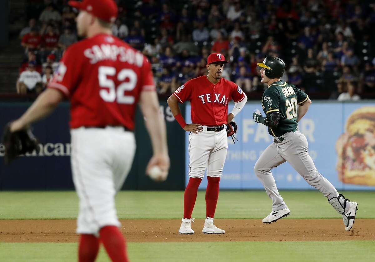 Texas Rangers' Adrian Sampson (52) walks back to the mound as first baseman Ronald Guzman watches Oakland Athletics' Mark Canha, right, round the bases on a solo home run in the fourth inning of the second baseball game of a doubleheader in Arlington, Texas, Saturday, June 8, 2019. (AP Photo/Tony Gutierrez)
