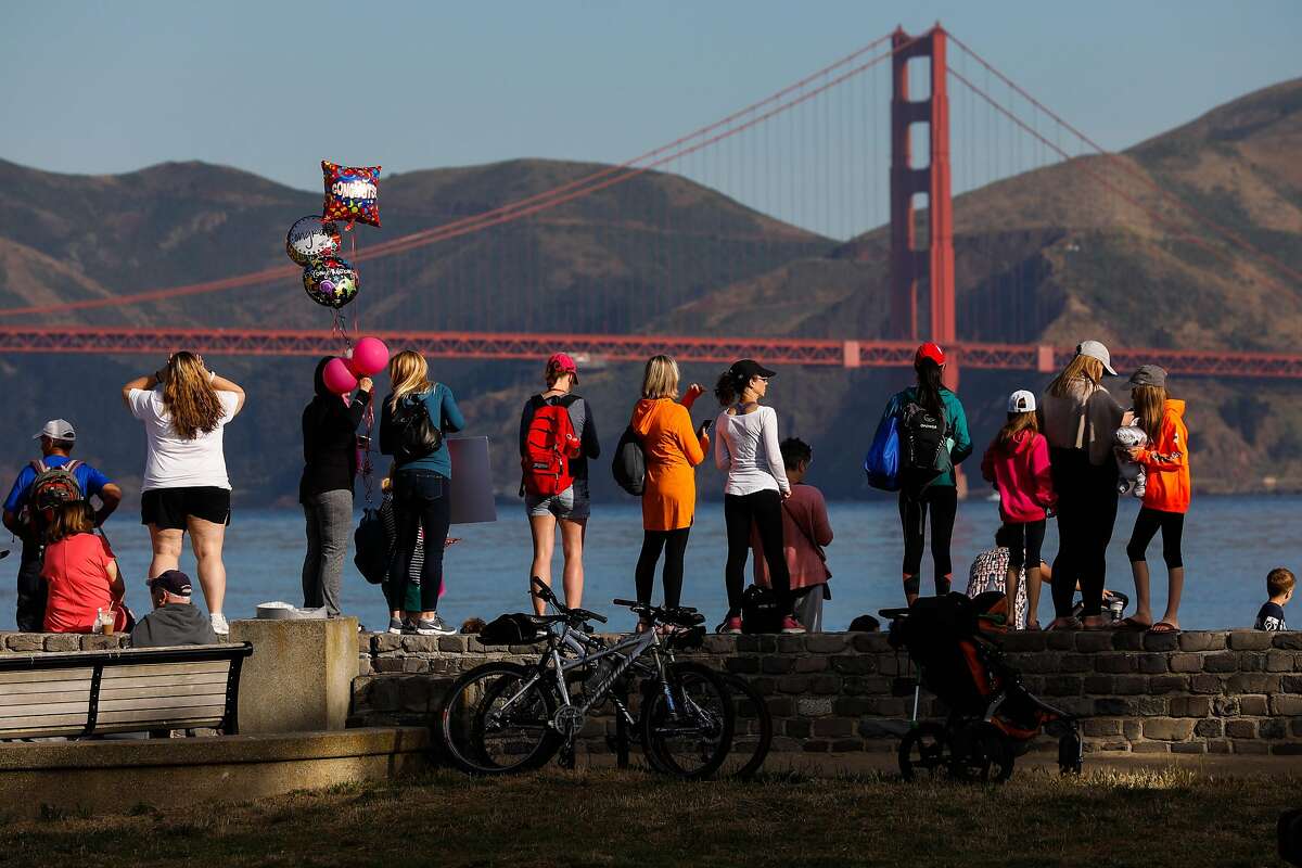 Spectators wait for the first swimmers to appear during the 39th annual Escape from Alcatraz Triathalon in San Francisco, California, on Sunday, June 9, 2019. Over 2,000 athletes swam the 1.5 miles to shore followed by an 18-mile bike ride and an 8-mile run through San Francisco. The race is considered one of the oldest and most difficult triathlons with many elite participants.