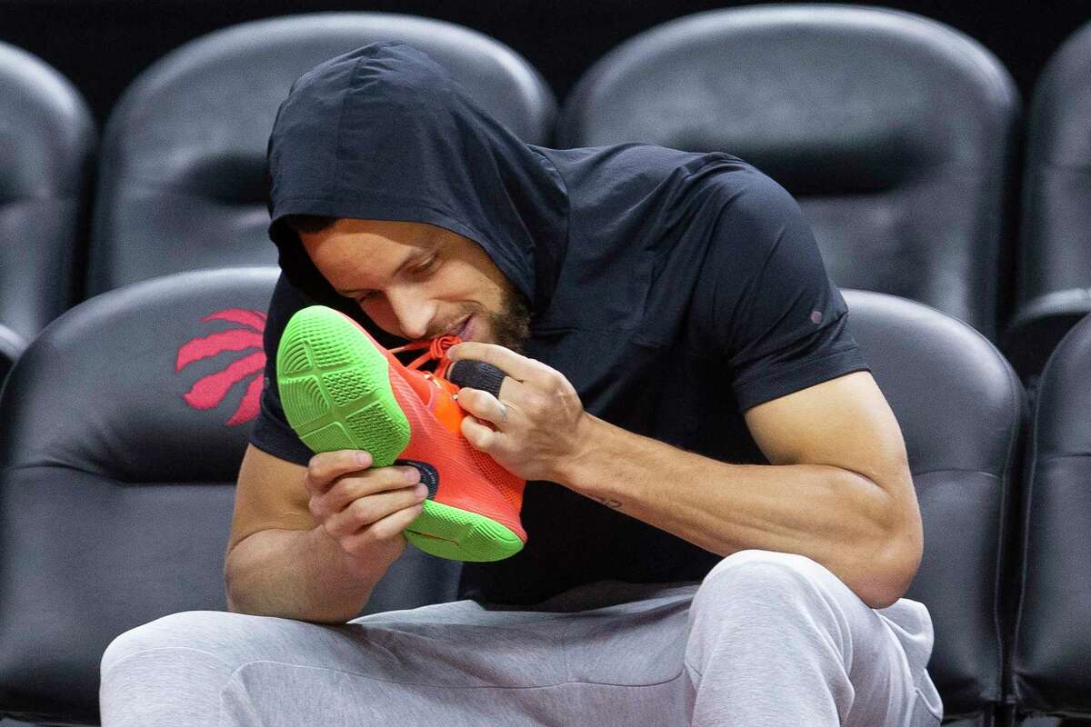 Golden State Warriors guard Stephen Curry bites his shoe laces during an NBA basketball practice in Toronto, Sunday, June 9, 2019, ahead of Monday's Game 5 of the NBA Finals against the Toronto Raptors. (Chris Young/The Canadian Press via AP)