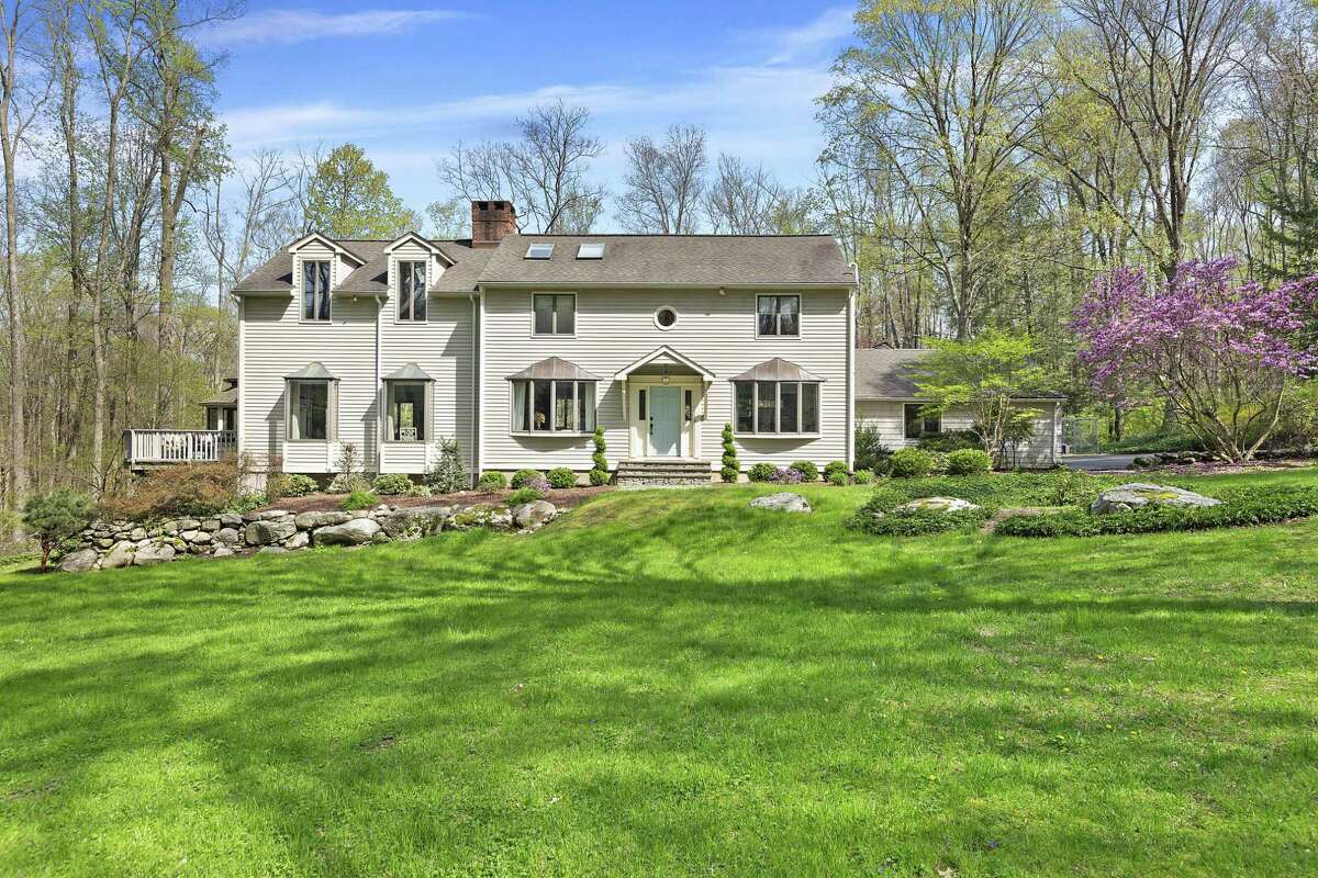 The white clapboard colonial house at 41 Godfrey Road West in Weston is within walking distance of Devil’s Den Nature Preserve.