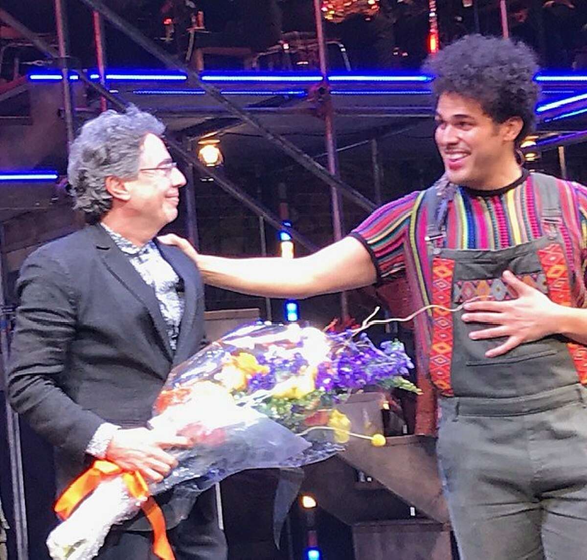 Tony Taccone receives bouquet from Joel Perez onstage after opening of "Kiss My Aztec" at Berkeley Rep