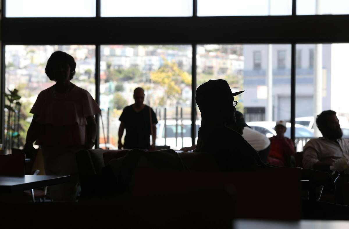 Staff and clients are silhouetted against the windows of the cooling station at the Dr. George W. Davis Senior Center on Monday, June 10, 2019 in San Francisco, Calif.