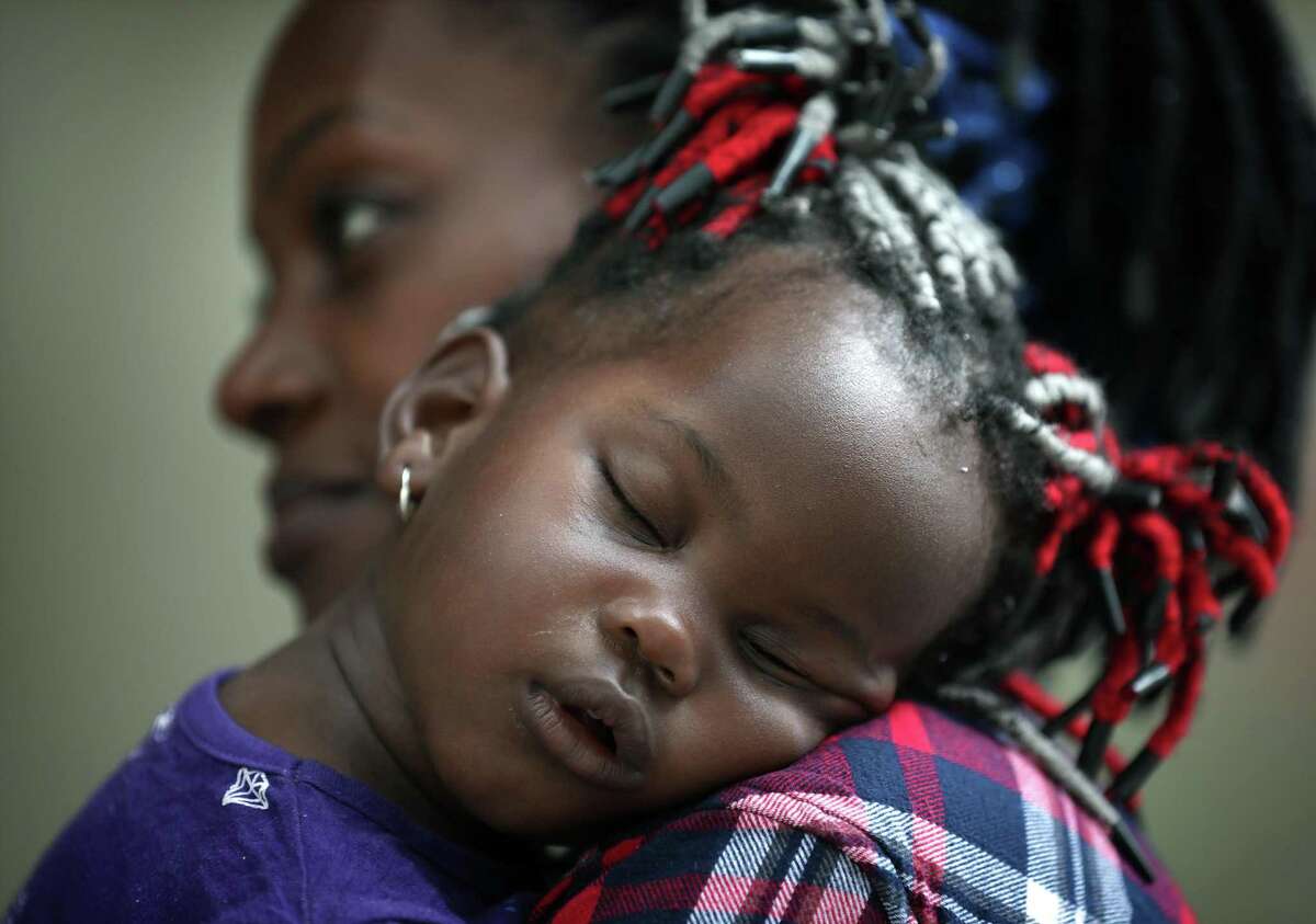 Valeria Atunga Keke, of Congo, holds her sleeping daughter Dandara Keke Makambo outside the shelter in San Antonio where she, her husband and three children have stayed for the past four days.