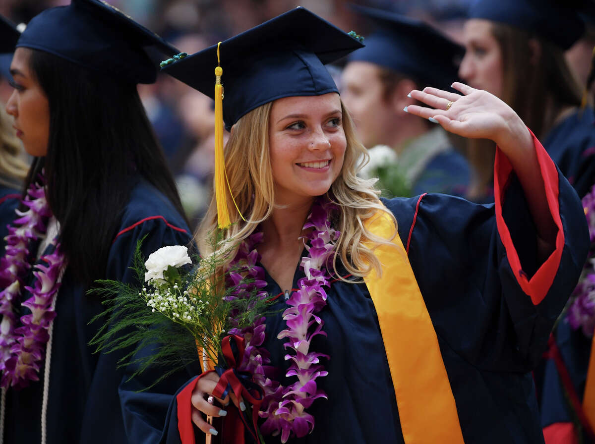 Graduate Kelly Strom waves to family in the stands during the Foran High School Graduation in Milford, Conn. on Monday, June 10, 2019.