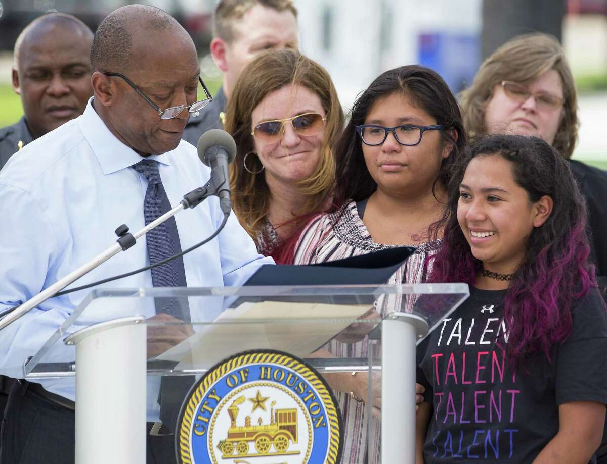 Mayor Sylvester Turner reads a proclamation to the family of Lesha Adams, shown from left, Stephanie Marsh, Olivia Adams-Marsh and Ava Marsh, during a news conference following the installation of a crosswalk near 10th and Shepherd as part of the city's Safer Streets initiative on Monday, June 10, 2019, in Houston. The traffic signal was installed at the location where Lesha Adams was helping Jesus Perez, who was in a wheelchair, cross the street on March 30 and were hit and killed by a car at the intersection