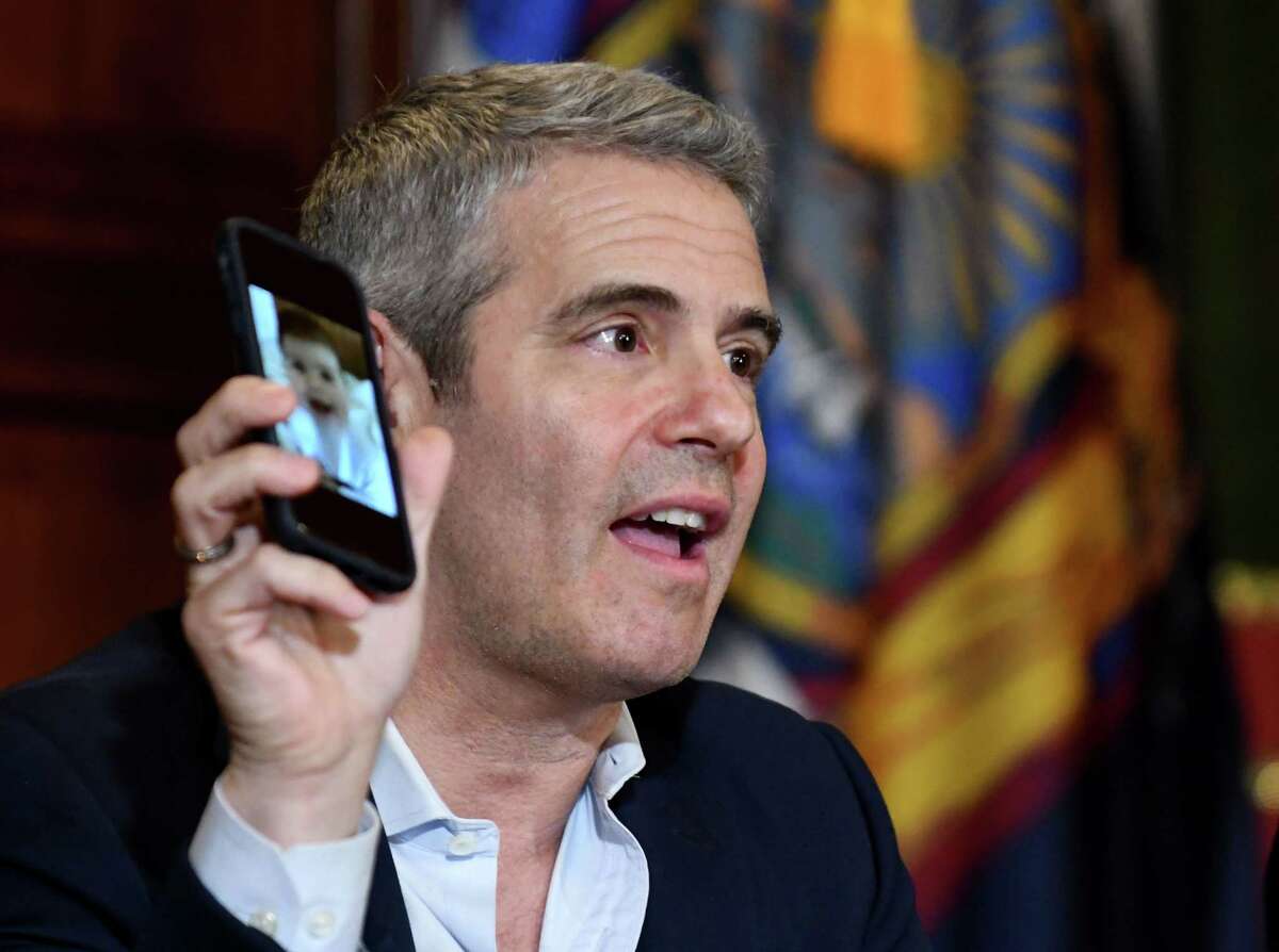Andy Cohen, producer and surrogacy advocate, holds photo of his son while joining Gov. Andrew Cuomo in a press conference in support of the surrogacy bill on Tuesday, June 11, 2019, at the Capitol in Albany, N.Y. The bill, if passed, would bring New York in line with more than three dozen states that have legalized the practice, in which a surrogate carries a child they are not related to for someone else. New York is currently one of three states that outlaw gestational surrogacy agreements. (Will Waldron/Times Union)