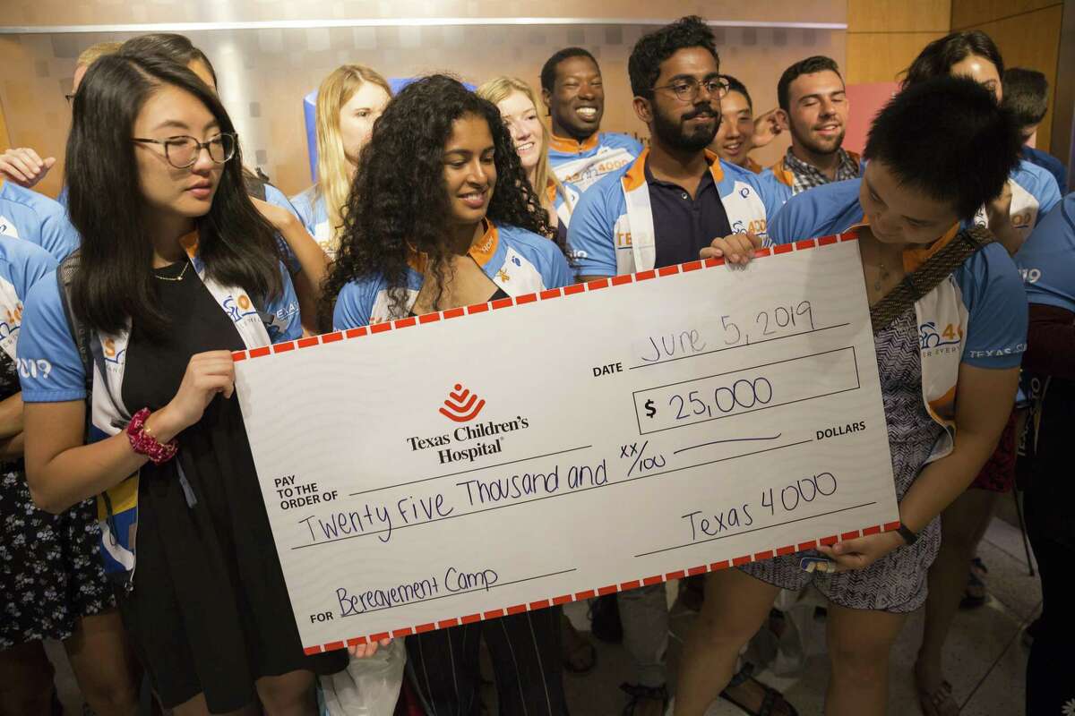 Members of Texas 4000 UT Austin team present a $25,000 check to support The Texas Children's Hospital's Retiro de Renovación program in Houston, Wednesday, June 5, 2019. The team, which hopes to raise money for cancer research and support services, visited with patients and toured the hospital.