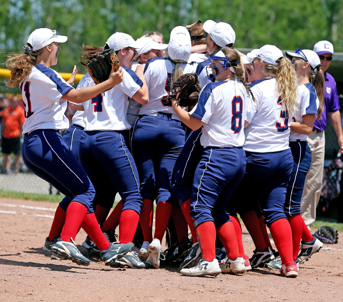 The USA softball team celebrates following its 13-0 Division 4 quarterfinal victory over Allen Park Inter-City Baptist, Tuesday, at Saginaw Valley State University.