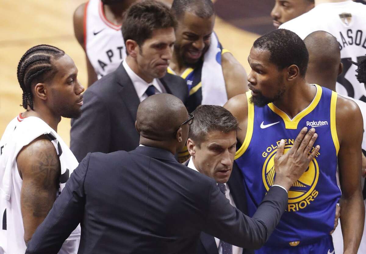 Toronto’s Kawhi Leonard (left) and the Warriors’ Kevin Durant, seen after Durant’s injury in the second quarter of Game 5 of the NBA Finals, embody the fickle nature of NBA free agency.