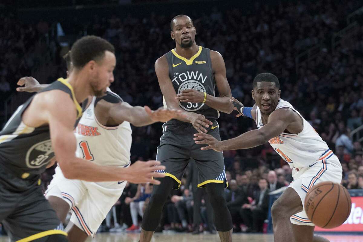 Golden State Warriors forward Kevin Durant, center, passes the ball to guard Stephen Curry (30) during the first half of an NBA basketball game against the New York Knicks, Friday, Oct. 26, 2018, at Madison Square Garden in New York. (AP Photo/Mary Altaffer)