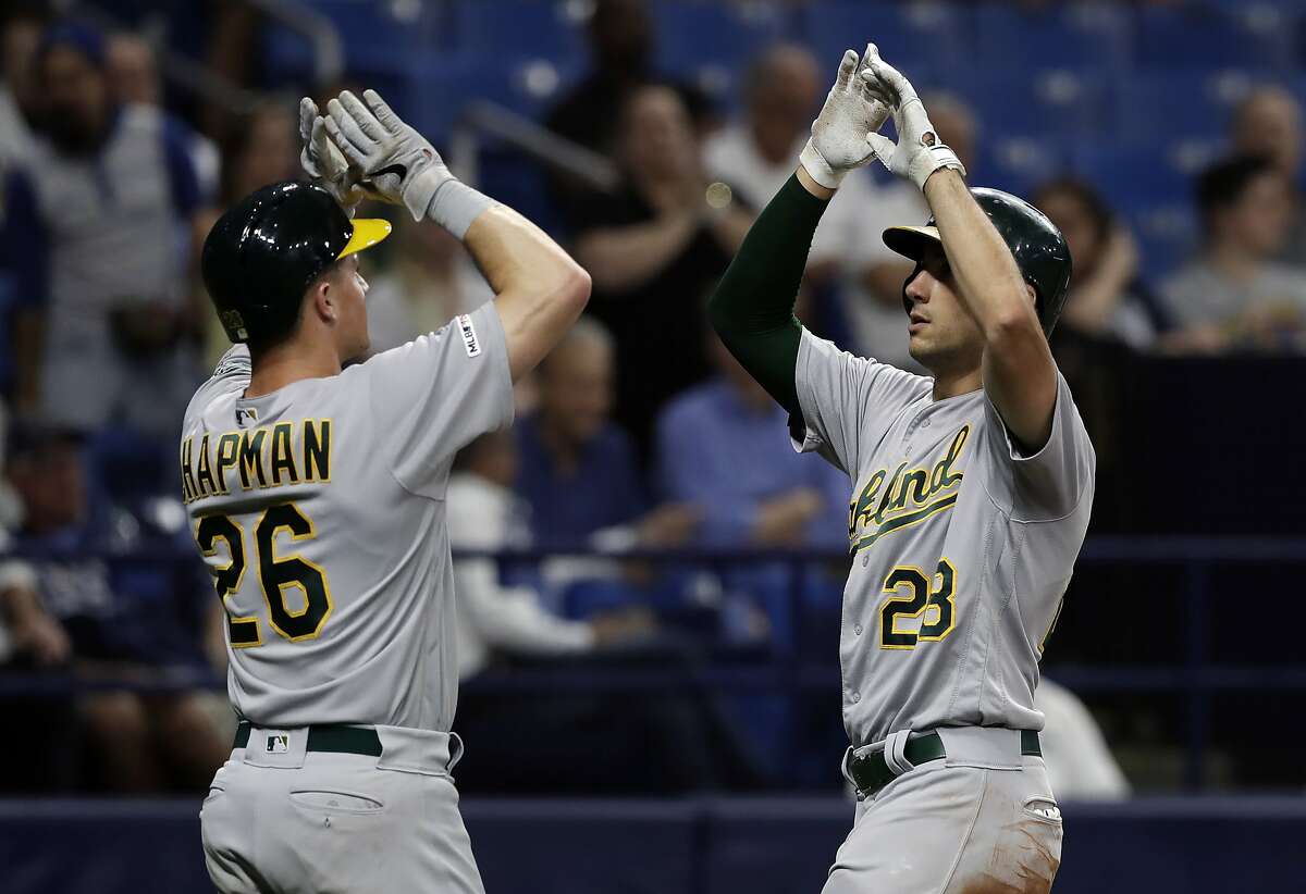Oakland Athletics' Matt Olson, right, celebrates with Matt Chapman after Olson hit a two-run home run off Tampa Bay Rays relief pitcher Emilio Pagan during the sixth inning of a baseball game Tuesday, June 11, 2019, in St. Petersburg, Fla. (AP Photo/Chris O'Meara)