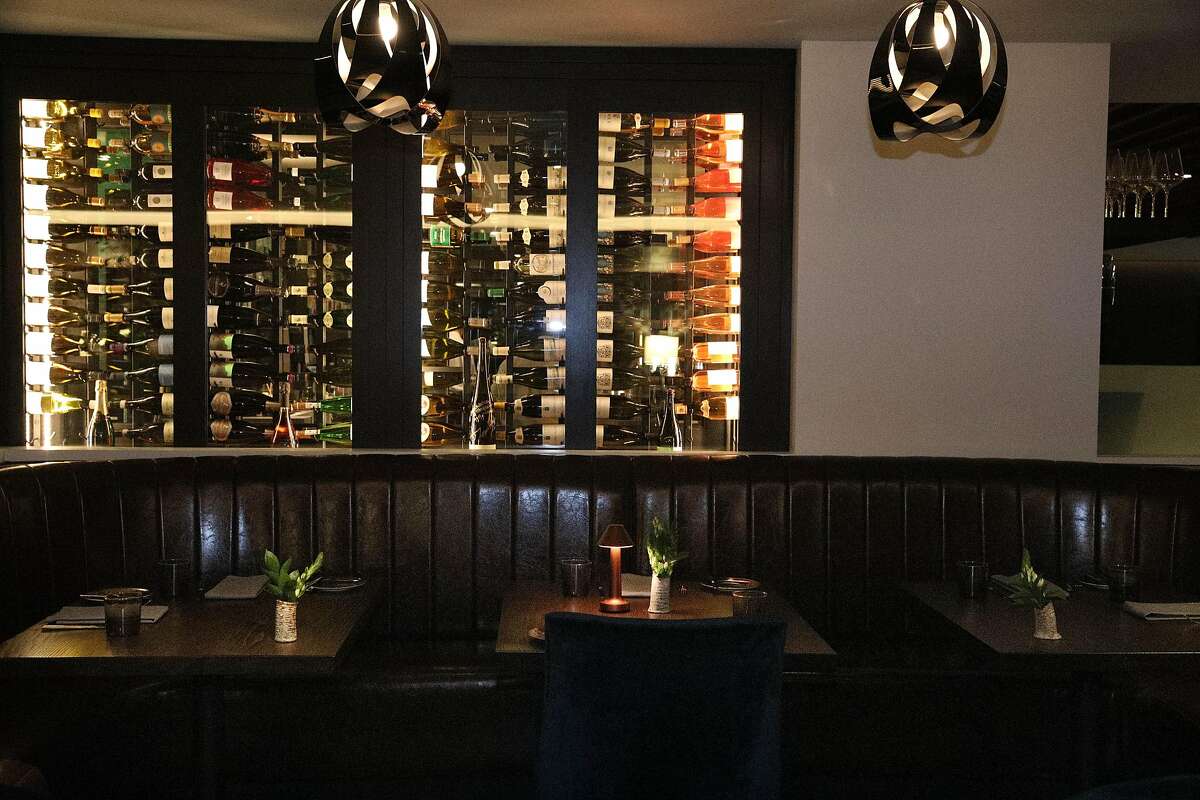 Champagne on racks in the dining room are seen behind booth seating at The Vault on Tuesday, June 4, 2019 in San Francisco, Calif.