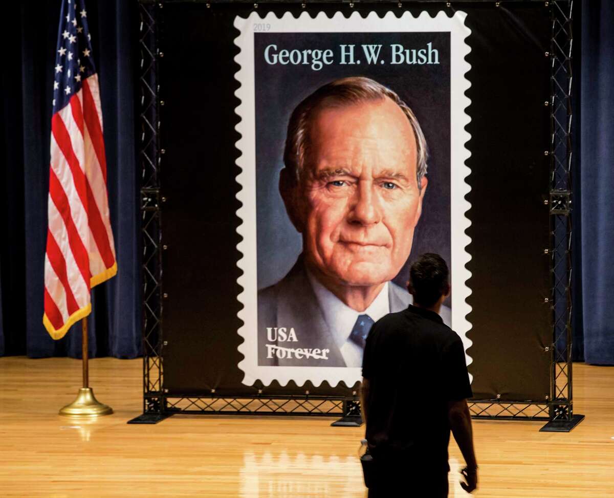 A man walks by the large scale Forever Stamp honoring former President George H.W. Bush on Wednesday, June 12, 2019, in College Station. The first-day-of-issue ceremony coincides with Bush's birthday. The Forever stamp features a portrait of the 41st president painted by award-winning artist Michael J. Deas.