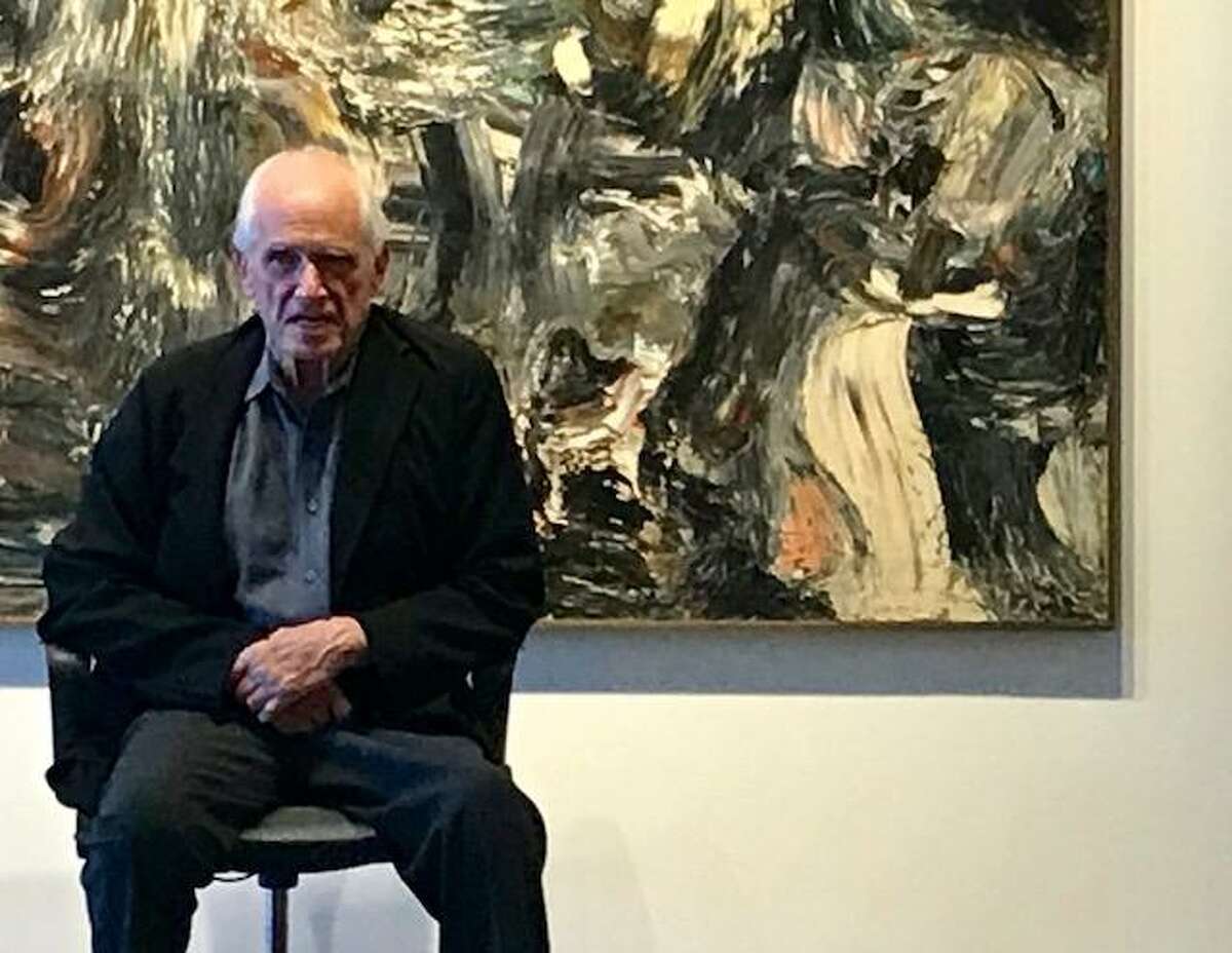 Jim Newman sits in front of a Robert Morris painting at a celebration of Dilexi Gallery.