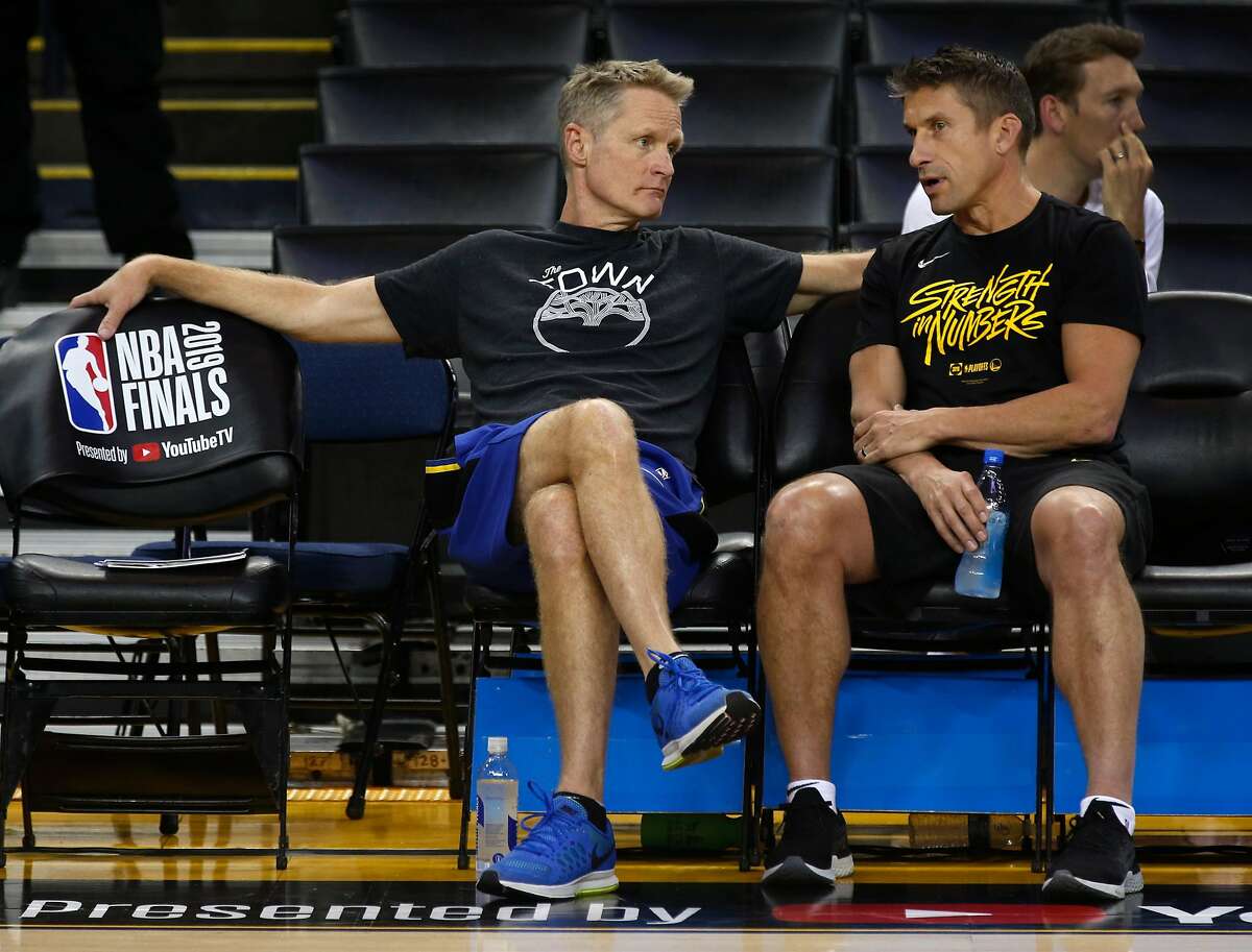 Head coach Steve Kerr confers with director of sports medicine and performance Rick Celebrini during a Golden State Warriors practice at Oracle Arena in Oakland, Calif. on Wednesday, June 12, 2019 before Thursday's Game 6 of the NBA Finals against the Toronto Raptors.