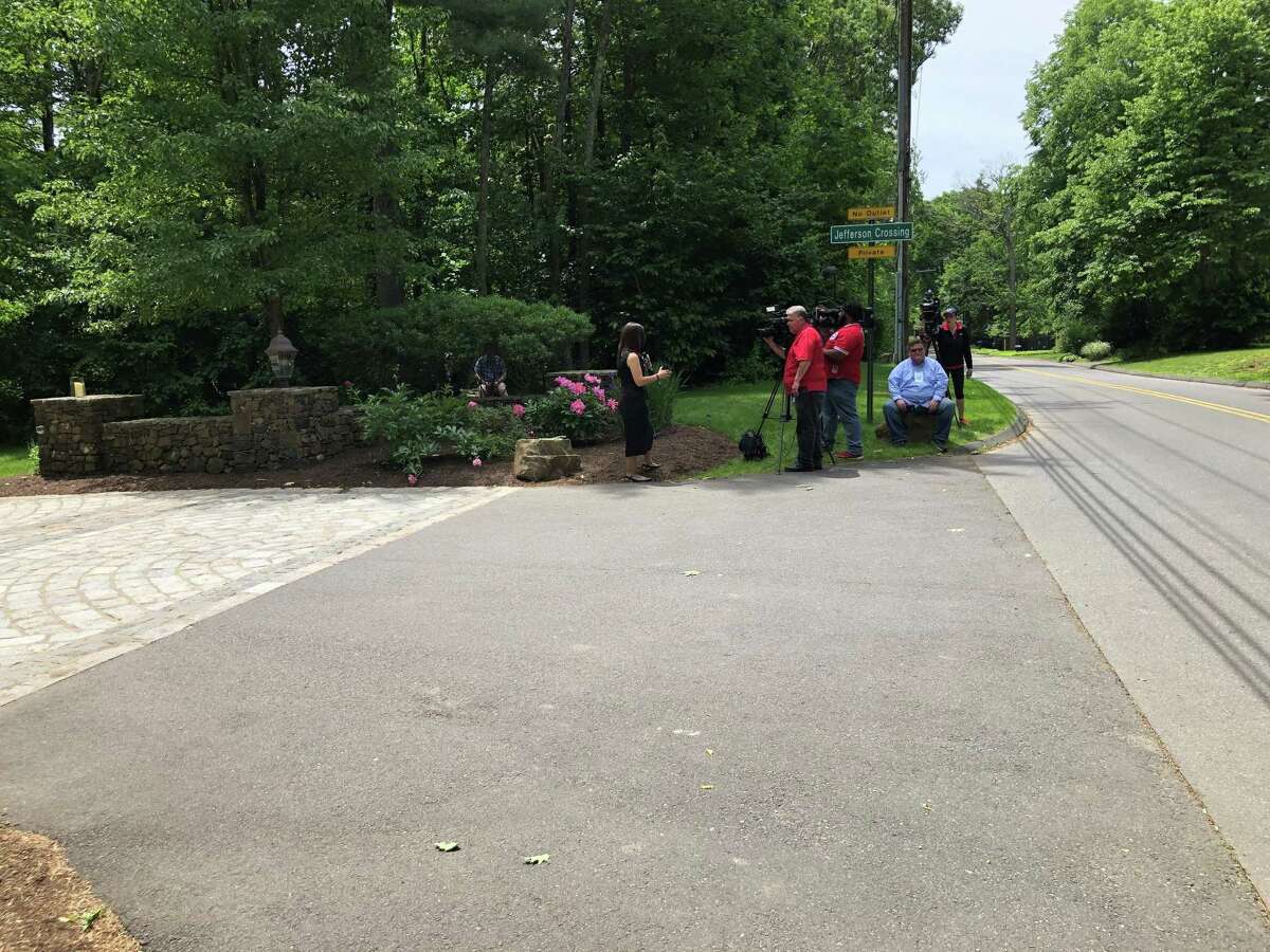 Members of the media gather at the entrance to Jefferson Crossing, a private Farmington road lined with multimillion dollar homes built by Fotis Dulos’ company, the Fore Group.