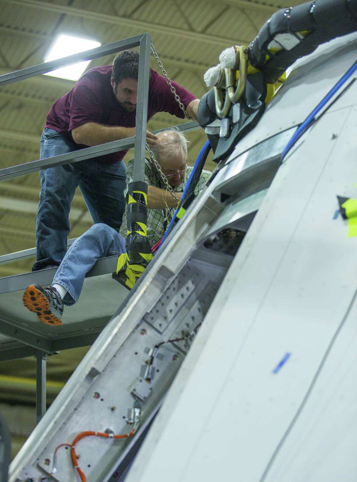Engineers remove a data recorder that is part of testing of the capsule that will be used during Orion's Ascent Abort 2 test next year, at NASA's Johnson Space Center, Thursday, Sept. 13, 2018 in Houston. Engineers are currently testing systems that will fire during the capsules flight that will test the ability of the Orion capsule to abort if something goes wrong during launch.