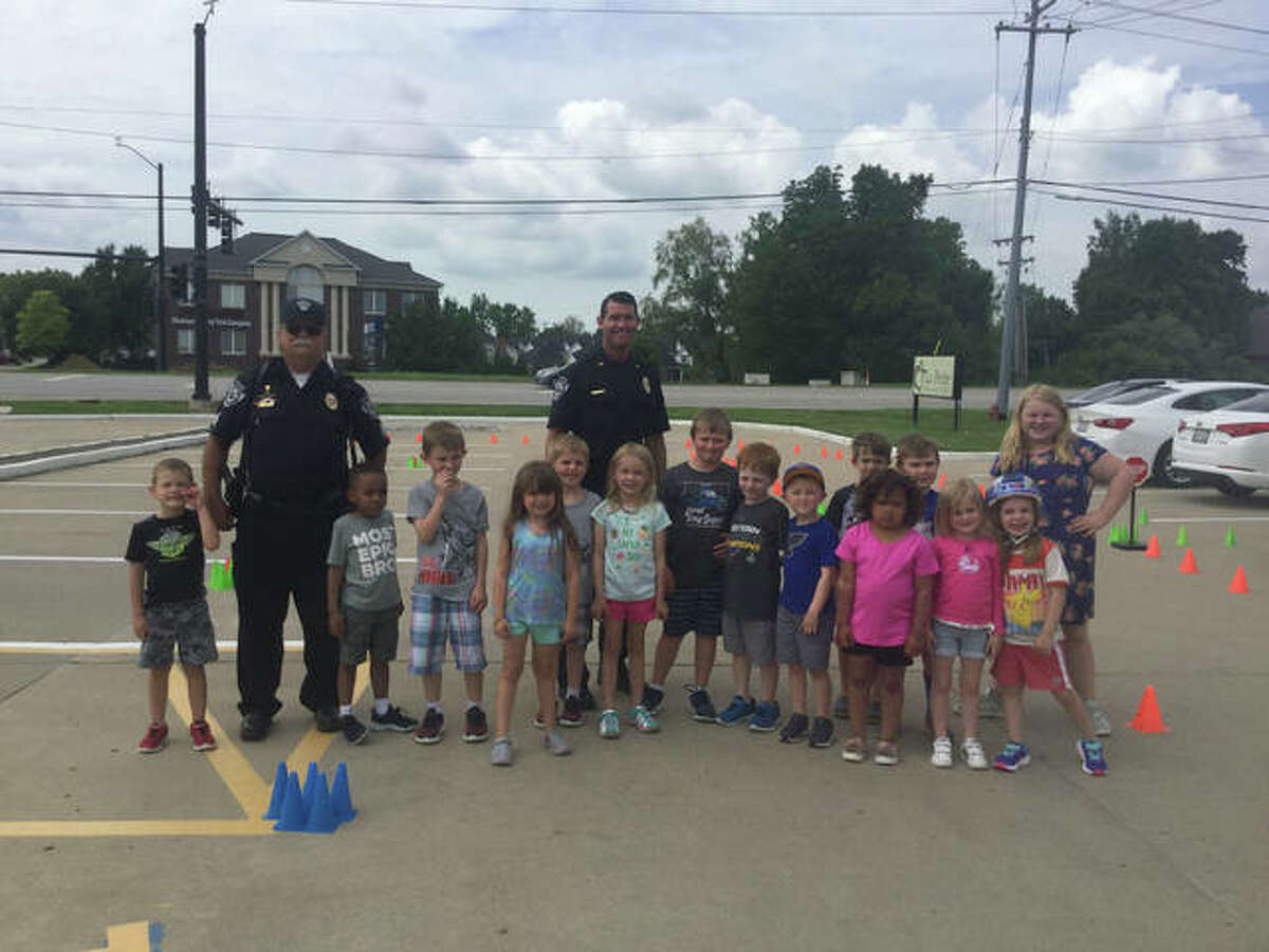 Lt. White and Sgt. Jones pose with the La Petite students and their teacher during a bike safety rodeo.