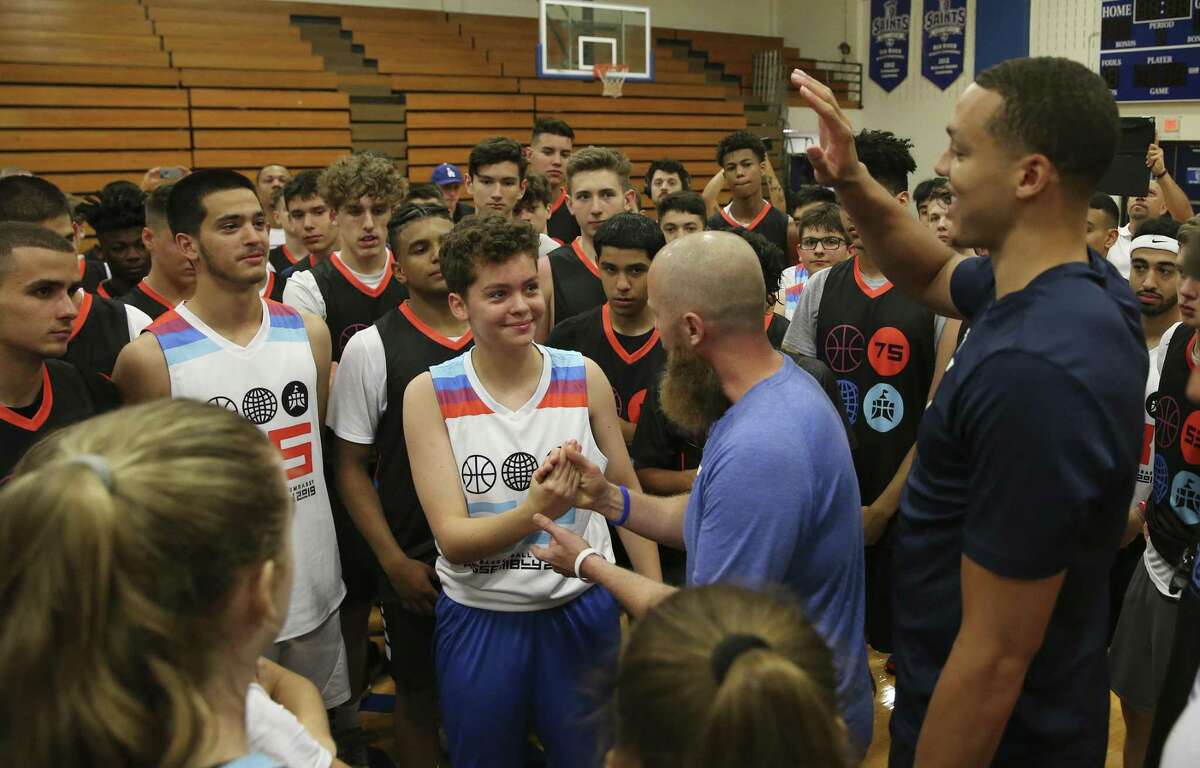 Fjolla Ajeti, 15, center, left, of Kosovo, high fives Train the Mind co-founder Graham Betchart, center right, and the Orlando Magic's Aaron Gordon, right, at Our Lady of the Lake University during a Train the Mind educational session. Train the Mind is an online program out of San Antonio that provides mental coaching to teen athletes to better handle intense competition.